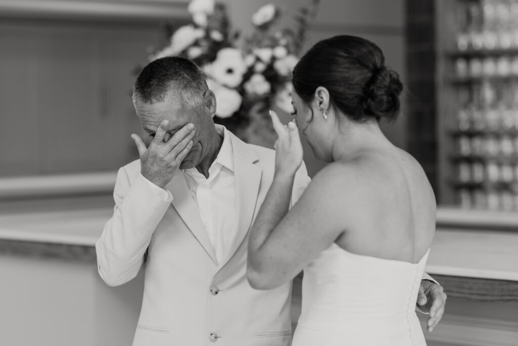 Bride, in white strapless dress, seeing her dad, in tan suit, for the first time at The Ruth wedding venue in Charlotte NC. Photographed by Charlotte Wedding Photographer.